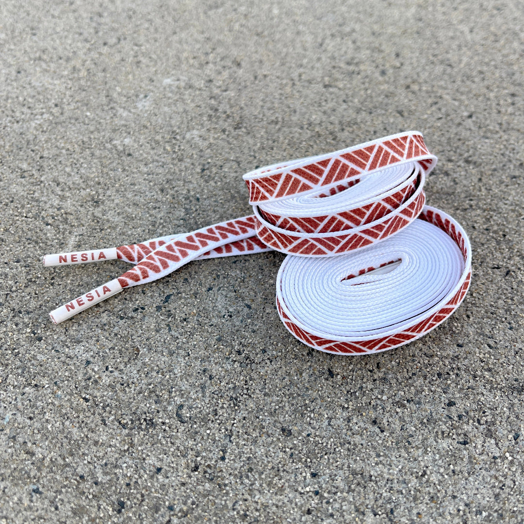 Nesia Originals Polynesian Tapa design shoelaces rolled up on cement background